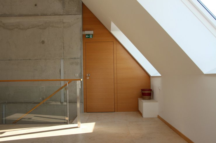 Beton und Holz Stilsichere Kombination aus Wandvertäfelung und eingelassener Tür